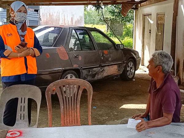 Wan Nor Hayati (kiri) bertanyakan khabar Abdullah ketika berkunjung ke rumahnya di Kampung Banggol Pak Esah, Selising, Pasir Puteh pada Khamis.