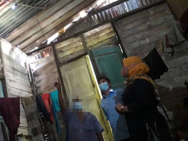 Masri (kiri) menunjukkan bahagian struktur bumbung yang melengkung dan zink yang sudah bocor kepada Aisyah (kanan) dan Abdul Rahman di rumahnya di Kampung Pinggiran, Gelang Patah, Iskandar Puteri pada Khamis.