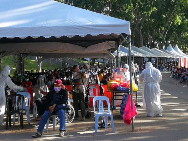 Petugas barisan hadapan membantu individu yang hadir di CAC Stadium Malawati, Shah Alam pada Khamis.