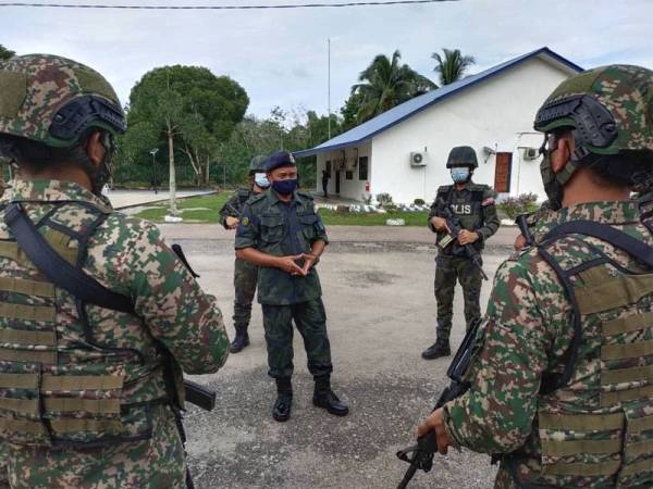 Azhari (tengah) membincangkan sesuatu dengan anggota ATM melalui kerjasama menerusi Op Bersepadu ATM yang menunjukkan kesan positif dalam aspek kawalan sempadan di negeri ini.