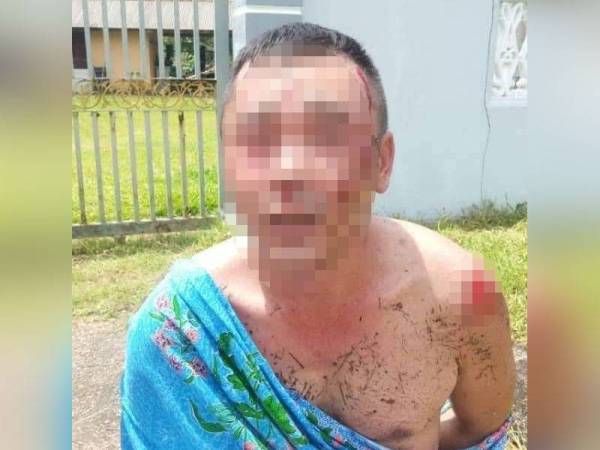 Suspek dipakaikan kain batik untuk sementara semasa di lokasi. - Foto ihsan polis