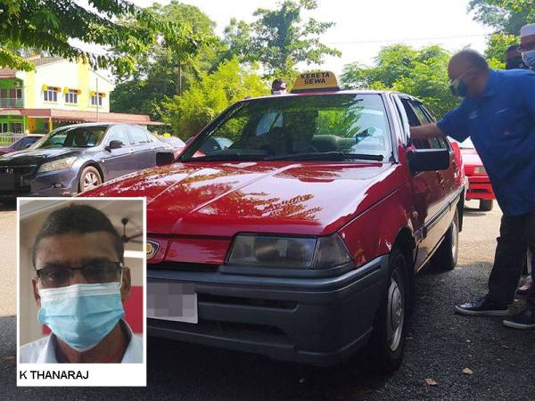 Ahmad Shalimin (kanan) menyerahkan pek makanan keperluan asas kepada pemandu teksi secara pandu lalu di Pusat Khidmat Barisan Nasional Taiping pada Sabtu.