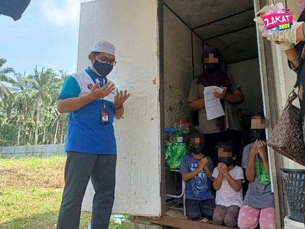 Wakil MAINJ membaca doa semasa melawat dan memberi sumbangan Junaidah yang tinggal dalam kontena di Kampung Baru Seri Aman, Jalan Kempas Lama Tebrau, Johor Bahru, pada Jumaat.