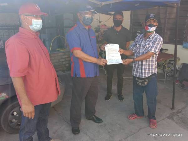 Noh (dua dari kiri) menyampaikan cek kepada wakil Surau Kampung Tok Empat Masjid di sini pada Sabtu.