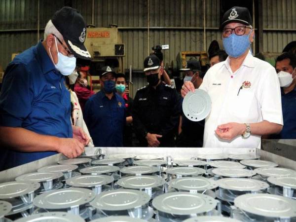 Timbalan Perdana Menteri Datuk Seri Ismail Sabri Yaakob (kanan) bersama Menteri Dalam Negeri Datuk Seri Hamzah Zainudin (kiri) ketika menyertai serbuan Ops Patuh di sebuah kilang pembuatan logam di Bukit Tinggi. - Foto Bernama
