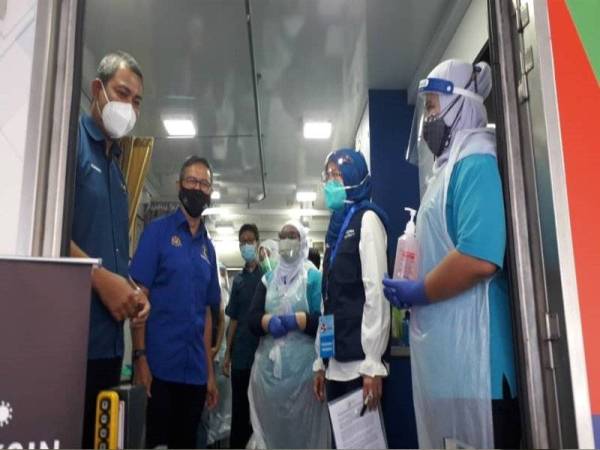 Mohd Rashid (dua dari kiri) dan Setiausaha Perikatan Nasional (PN) Johor, Datuk Dr Sahruddin Jamal (kiri) bertemu petugas barisan hadapan di Dewan Serbaguna PPR Sri Stulang, Johor Bahru pada Ahad.