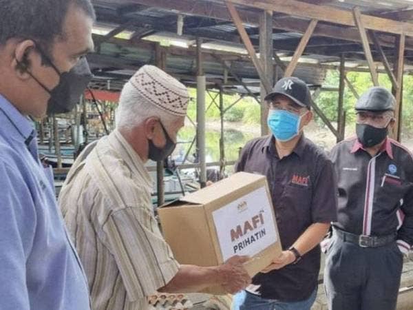 Dr Ronald melaksanakan tinjauan mesra di Pasar Nelayan Kampung Pasir Putih di sini dan menyampaikan bantuan bakul makanan kepada 100 nelayan. Foto Bernama