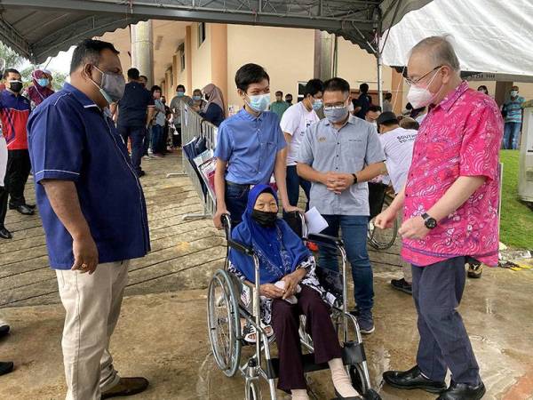 Ka Siong (kanan) beramah mesra dengan warga emas Jawiah Hajinor, 97, (berkerusi roda) yang selesai mendapatkan suntikan vaksin di PPV Integrasi Che Ann Khor, di Yong Peng, hari ini. - Foto Bernama