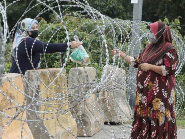 Penduduk Taman Seri Inderapura menerima juadah raya yang diberikan melalui kawat berduri berikutan taman berkenaan kini berada dalam Perintah Kawalan Pergerakan Diperketatkan.