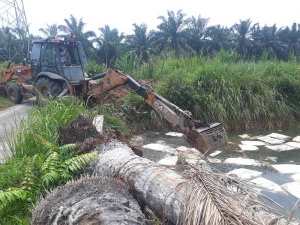 Jentera pengaut sedang membersihkan sisa buangan di tali air berkenaan.