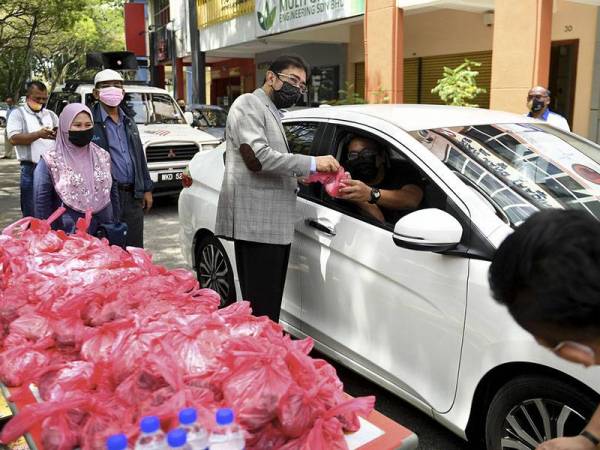 Timbalan Menteri Komunikasi dan Multimedia Datuk Zahidi Zainul Abidin (empat, kiri) menyampaikan sumbangan daging korban dan bakul makanan kepada petugas media secara pandu lalu menerusi Program Agihan Korban Aidiladha di hadapan bangunan Institut Kerjasama Islam Antarabangsa Malaysia (IKIAM) hari ini.