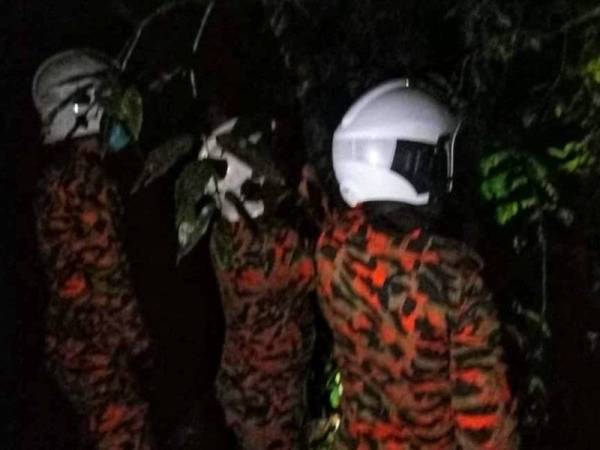 Anggota bomba berusaha memujuk seorang wanita yang dipercayai alami gangguan mental di Kampung Keledek pada Rabu malam. FOTO: Ihsan Bomba