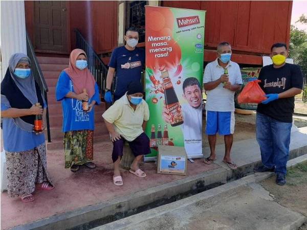Mohd Jazri (tiga dari kiri) dan Khairul Nizam (kanan) menyampaikan bantuan keperluan dapur kepada sebuah keluarga warga emas dan OKU di Kampung Nyatoh, Rantau.