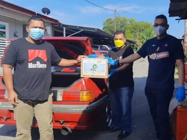 Mohd Jazri (kanan) dan Khairul Nizam (tengah) menyampaikan sumbangan Jiwa Peduli secara pandu lalu di Taman Kelab Tuanku Mambau, Seremban.