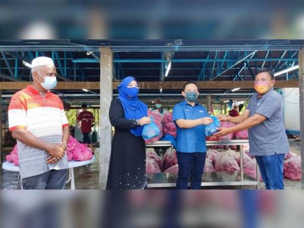 Wan Saiful (dua dari kanan) menyerahkan daging lembu kepada wakil penduduk untuk diagihkan sempena Program Ibadah Korban Pengerusi PTPTN di Parlimen Kubang Pasu pada Khamis. Turut kelihatan Halimaton Shaadiah (dua dari kiri).