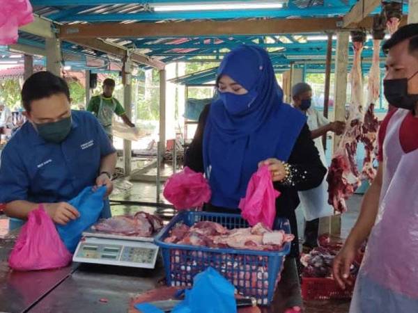 Wan Saiful (dua kiri) bersama Halimaton Shaadiah turut menimbang daging lembu untuk diagihkan sempena Program Ibadah Korban Pengerusi Perbadanan Tabung Pendidikan Tinggi Nasional (PTPTN) di Parlimen Kubang Pasu pada Khamis.