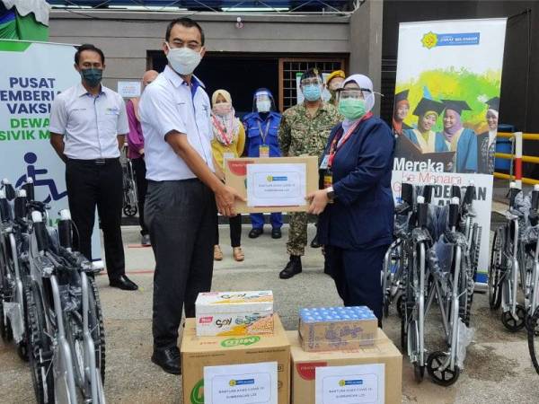 Saipolyazan (kiri) menyerahkan sumbangan makanan kering dan kerusi roda kepada pihak pengurusan PPV Dewan Sivik MBPJ di sini pada Khamis..