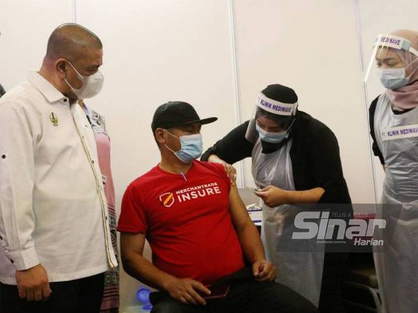 Saarani (kiri) melihat proses suntikan vaksin Covid-19 sempena lawatannya ke PPV PIKAS di Hotel Casuarina Meru pada Jumaat.