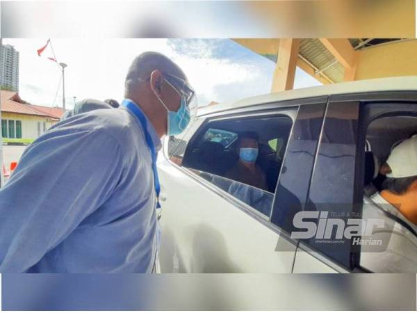 Naib Canselor USM, Profesor Datuk Dr Faisal Rafiq Mohamd Adikan sedang berbual dengan salah seorang penerima suntikan vaksin di PPV pandu lalu USM pada Jumaat.