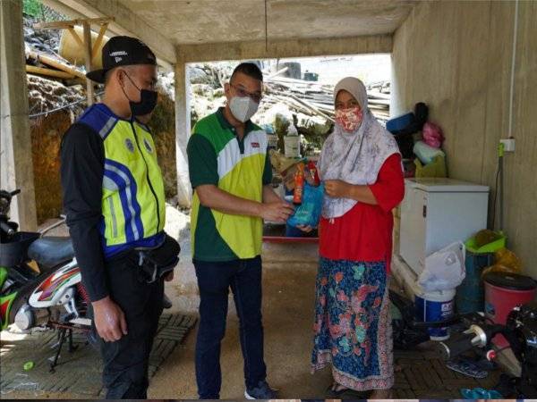 Mohd Jazri (tengah) menyerahkan daging korban kepada seorang penduduk Pulau Perhentian.