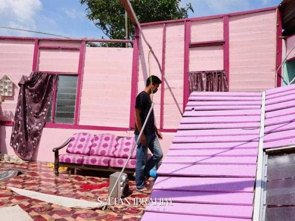 Seorang penduduk melihat keadaan rumah yang rosak terutama bahagian atap selepas dipukul ribut di Tanjung Sedili, Kota Tinggi, pada Sabtu.