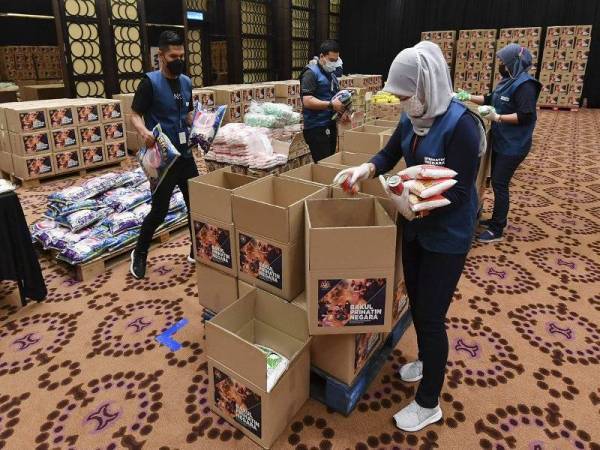 Kerja-kerja penyediaan bakul makanan di bawah program Bakul Prihatin Negara oleh sukarelawan Skuad Prihatin Negara di KPWKM.- Foto Bernama
