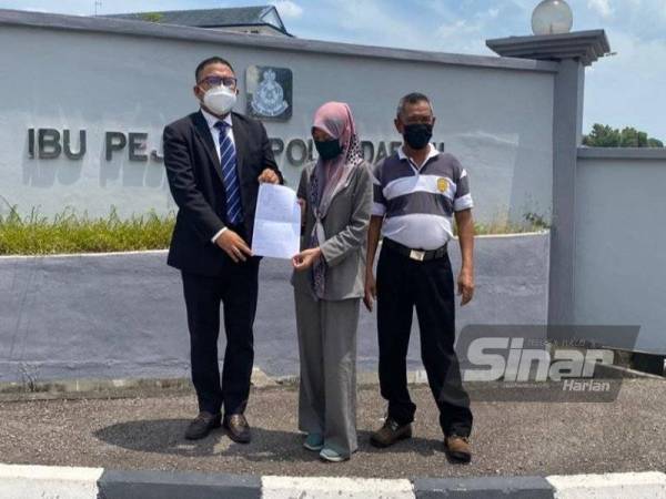 Mohamad Ashraf (kiri) ketika hadir ke Ibu Pejabat Polis Daerah Kuala Muda Kedah pada Ahad ketika laporan polis dibuat.