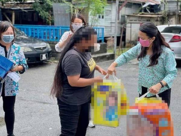 Hannah (kanan) bersama Wanita DAP Kuala Lumpur menyampaikan bantuan susu dan lampin pakai buang di Kampung Datuk Keramat