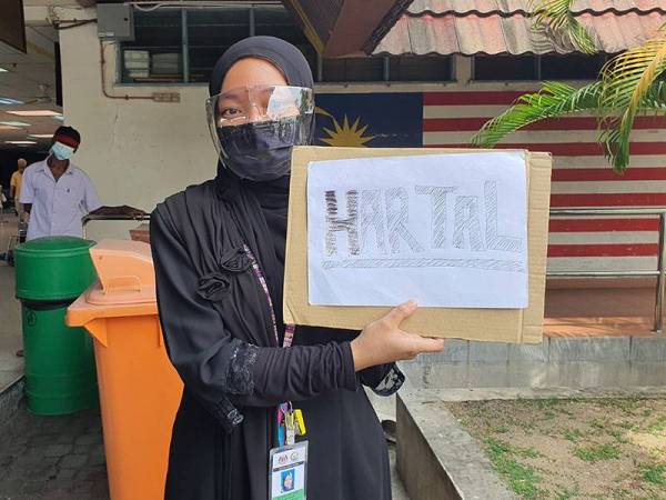 Dr Zakiah Hanim menunjukkan poster Hartal sebagai tanda protes.