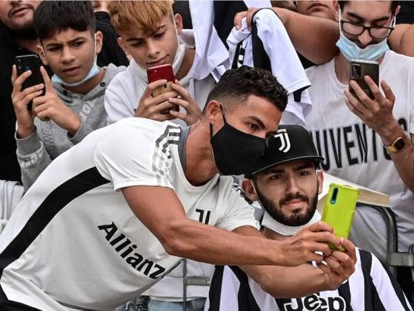 Ronaldo bergambar bersama penyokong Juventus sebaik tiba di pusat perubatan kelab tersebut di Turin. - Foto AFP