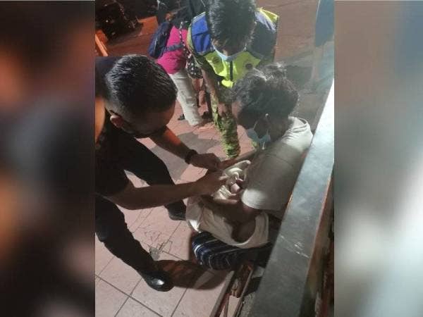 Pegawai polis memeriksa keadaan wanita dan anaknya yang baharu dilahirkan.