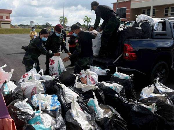 Anggota PGA mengangkat rampasan daun ketum ketika sidang media kejayaan Op Benteng di Agensi Kawalan Sempadan Malaysia (AKSEM) Bukit Kayu Hitam hari ini.

