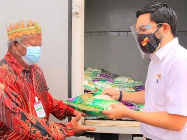 Tengku Amir (kanan) yang mewakili Sultan Sharafuddin menyampaikan beras kepada wakil penduduk Orang Asli Sungai Judah, Pulau Carey, di sini.