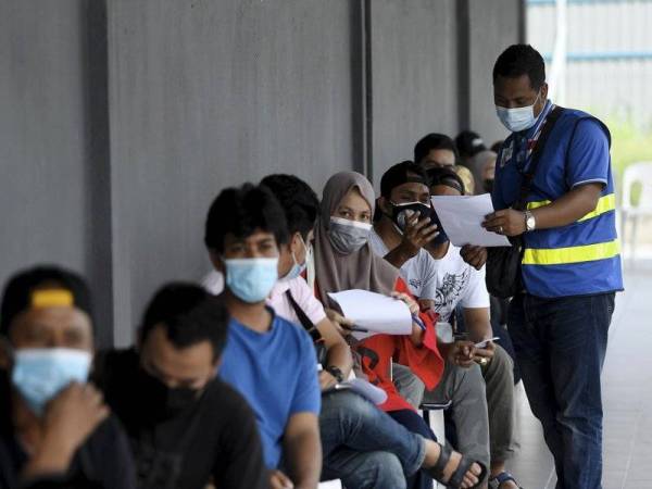 Penerima vaksin Covid-19 menunggu giliran di Pusat Vaksinasi dan Program Vaksinasi Bergerak yang dibuka kepada penduduk Program Perumahan Rakyat (PPR) dan Perumahan Awam Dewan Bandaraya Kuala Lumpur (DBKL) di Dewan Serbaguna Taman Melati Impian. - Foto Bernama