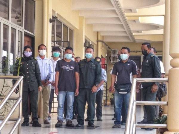 Kelima-lima tertuduh mengaku tidak bersalah dan dibawa keluar dari Mahkamah Raub pada Raub diiringi anggota penguatkuasa Jabatan Perhutanan Negeri Pahang