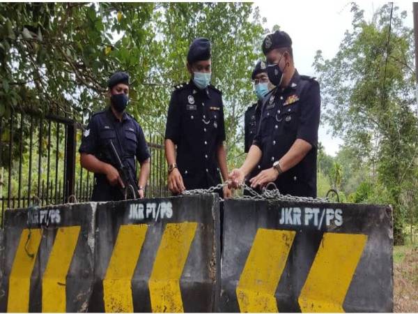 Mulkiaman (kanan) bersama anggotanya memeriksa penghadang konkrit yang telah dipasang semula bersama rantai besi di Jalan Bukit Tembaga, Kuala Nerang pada Khamis.