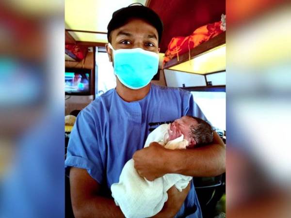 Pegawai perubatan Dr Dunstan Empawi dari Klinik Kesihatan Punan Ba di Ulu Merit mendukung bayi perempuan seberat 2.05 kilogram yang berjaya disambut kelahirannya di dalam sebuah bot ekspres ketika dalam perjalanan ke Hospital Kapit. - Foto Bernama