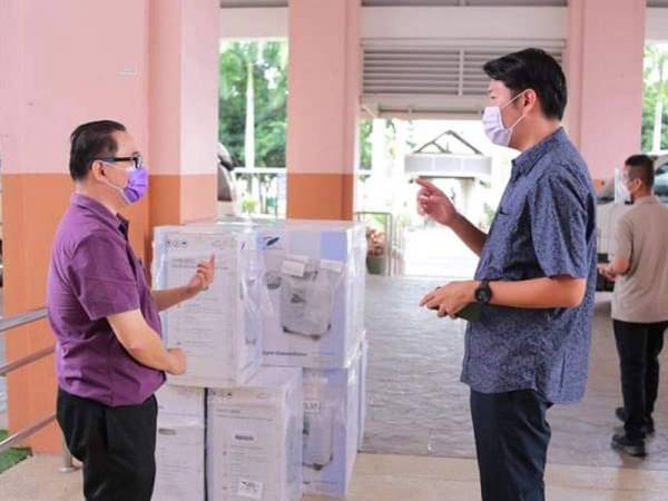 Simon (kanan) ketika hadir ke HSAH bagi menyerahkan mesin bantuan oksigen pada Khamis.