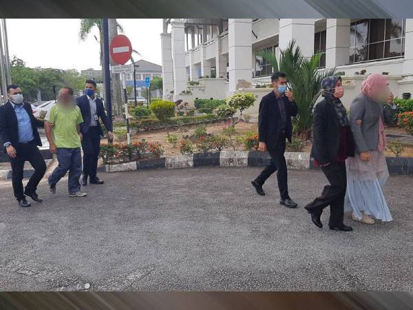 Haslin (depan, kanan) dan Mohd Irwan Redzuan (belakang, tengah) dibawa ke Mahkamah Seremban pada Jumaat.