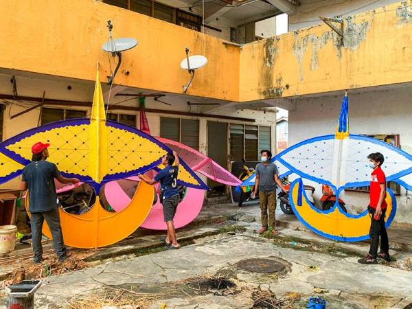 Pembuat wau tradisional Kelantan dikenali sebagai Wau Puyuh, Mohd Nasru Aiman Mohd Zu (kiri) bersama pekerjanya memeriksa sebahagian wau puyuh bersaiz sederhana besar. -Foto Bernama