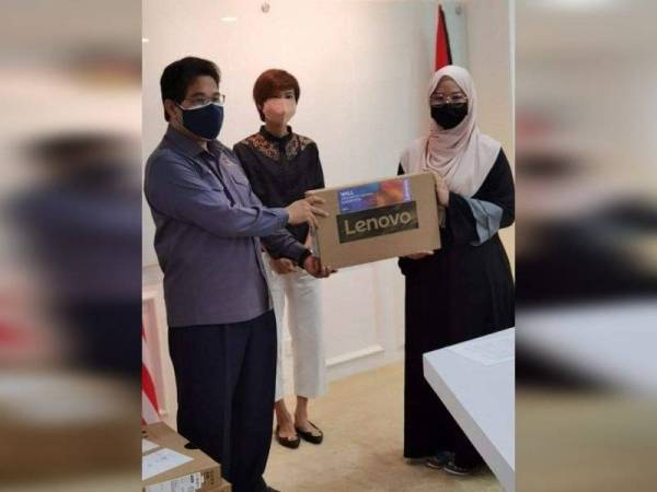 Mohammad Rafie menyampaikan sumbangan komputer riba.