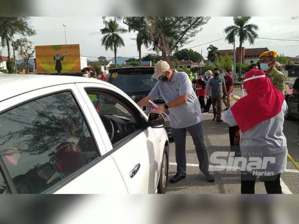 Mior Faridalathrash melekatkan Jalur Gemilang magnet di atas sebuah kereta pada Program Pelancaran Kempen Kibar Jalur Gemilang Peringkat Negeri Perak di Pusat Pemberian Vaksin (PPV) Stadium Indera Mulia pada Ahad.