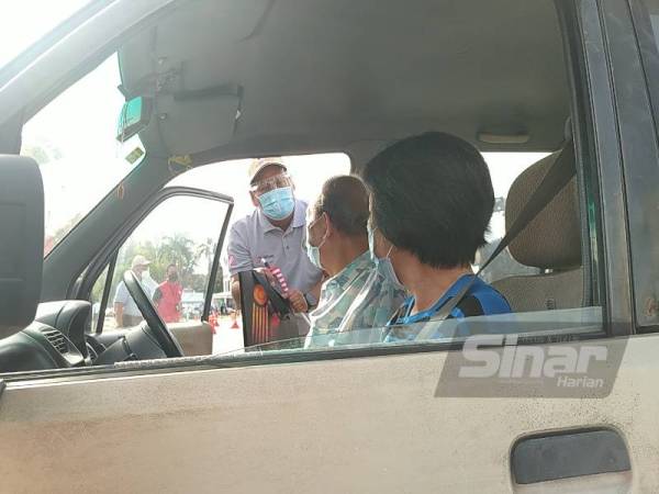 Khairul Shahril menyerahkan Jalur Gemilang kepada penerima vaksin sempena Program Pelancaran Kempen Kibar Jalur Gemilang Peringkat Negeri Perak di Pusat Pemberian Vaksin (PPV) Stadium Indera Mulia, di sini pada Ahad.