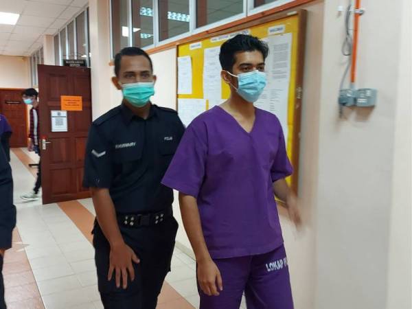 Muhammad Zaki (kanan) dibawa keluar dari Mahkamah Sesyen Kuala Kangsar pada Isnin selepas membayar jaminan RM10,000.