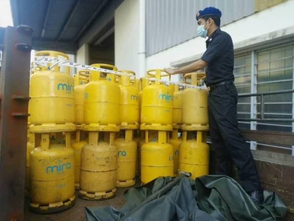Penguatkuasa KPDNHEP menunjukkan sebahagian tong LPG yang dirampas menerusi serbuan yang dilakukan di Taman Daya pada Sabtu.