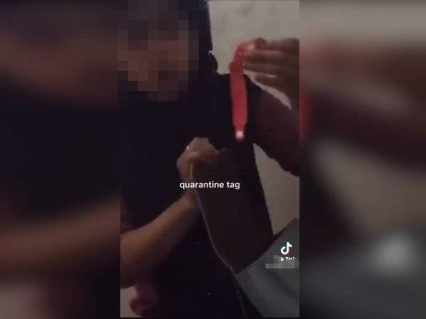 Tangkap layar daripada video yang menunjukkan tindakan remaja perempuan menanggalkan gelang 'pink' untuk keluar berjalan. - Foto ihsan pembaca.
