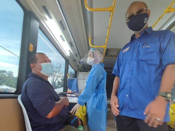 Mohd Asri Redha (kanan) meninjau proses vaksinasi di bawah program MOVAK di pekarangan Masjid Al-Husna, Kampung Padang Hassan, Alor Setar pada Khamis.