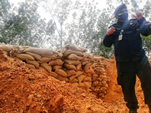 Mohammad Rafee di hadapan benteng pasir yang dibina di lokasi kejadian yang menemukan sebutir bom lama British seberat 226 kilogram pada Isnin lalu.