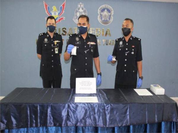 Mohd Hamizi (tengah) menunjukkan dadah yang berjaya dirampas dalam sekatan jalan raya di Kilometer 25 Jalan Kota Kinabalu-Tuaran.