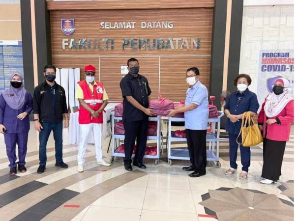 Rusli (tiga dari kanan) menyampaikan sumbangan pek makanan kepada Ketua Pegawai Polis Bantuan Fakulti Perubatan Hospital UiTM Sungai Buloh dan Puncak Alam, ASP/PB Khairul Azman Abu Bakar.